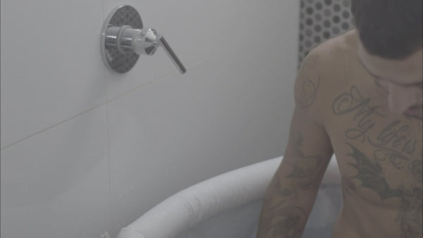 Hombre entrando en una bañera de hielo en su casa